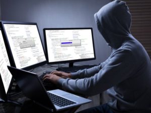 hacker using multiple computer screens